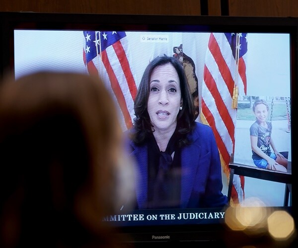 kamala harris is on a monitor as justice amy coney barrett sits in foreground