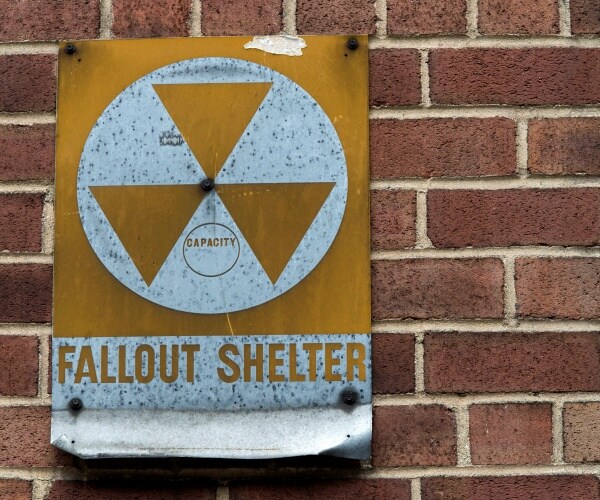 A fallout shelter sign hangs on a building 