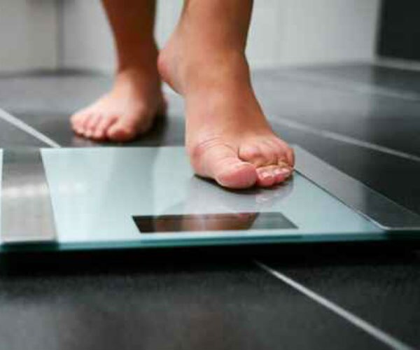 person stepping on weight scale