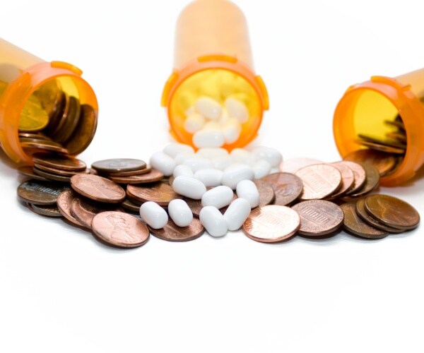 prescription medication vials with pennies spilling out