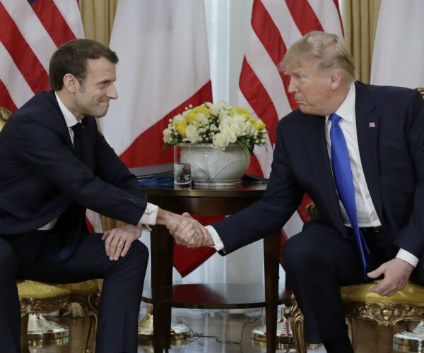 President Donald Trump shakes hands with French President Emmanuel Macron at Winfield House in London. 