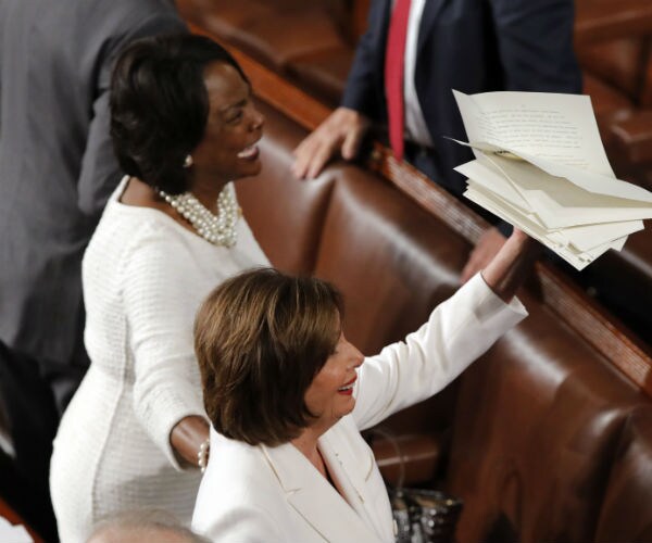 nancy pelosi is shown holding up the sotu speech