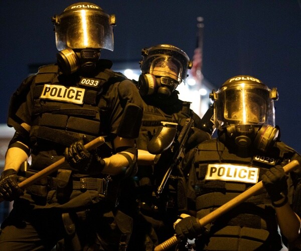 police officers in black uniforms wearing helmets