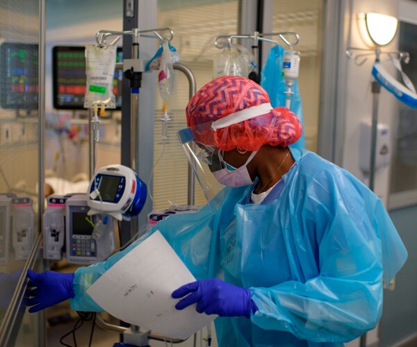 a healthcare worker enters an icu unit to see a coronavirus patient