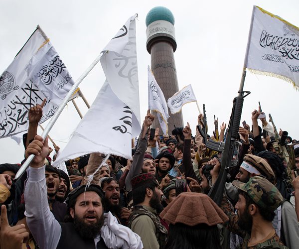 Men wave the flag of the Islamic Emirate of Afghanistan