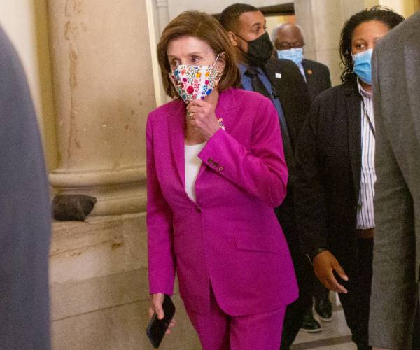pelosi in the capitol building wearing a mask
