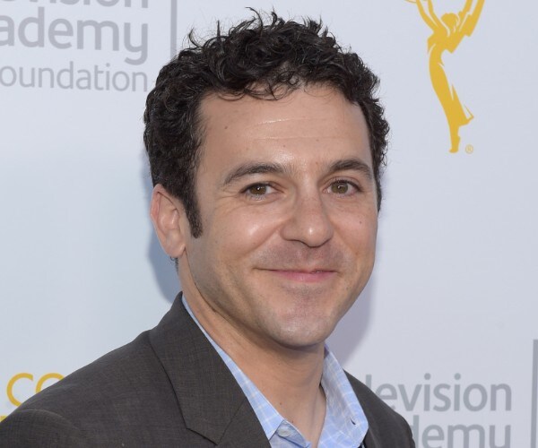 fred savage smiles on a red carpet