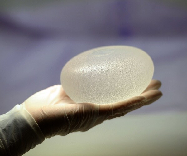 person holding silicone breast implant