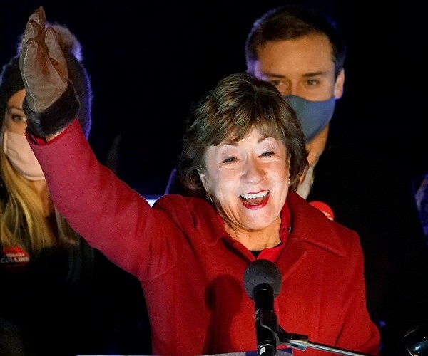 susan collins raises hand in victory