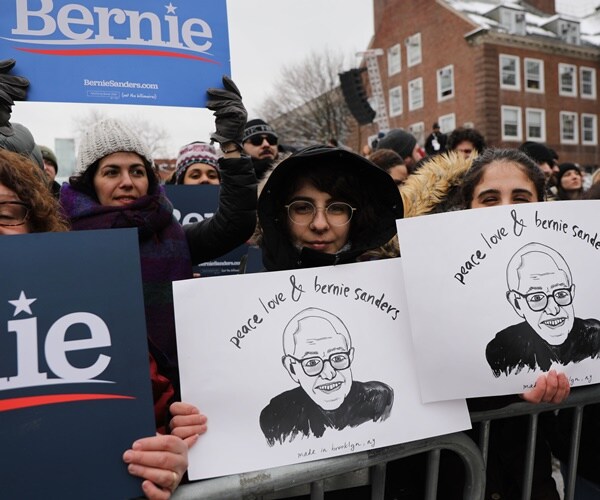 sanders supporters hold signs