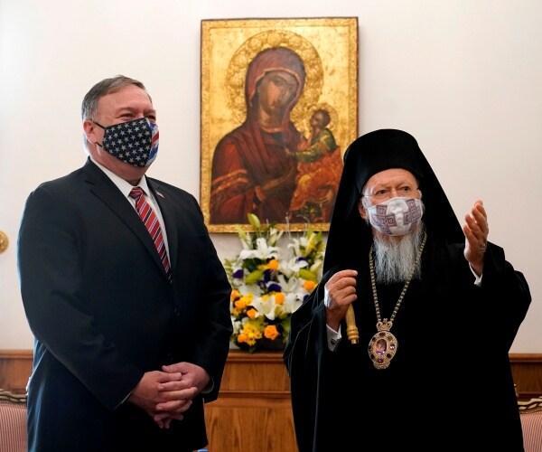 pompeo wearing a us flag mask standing next to bartholomew in black robes and a face mask