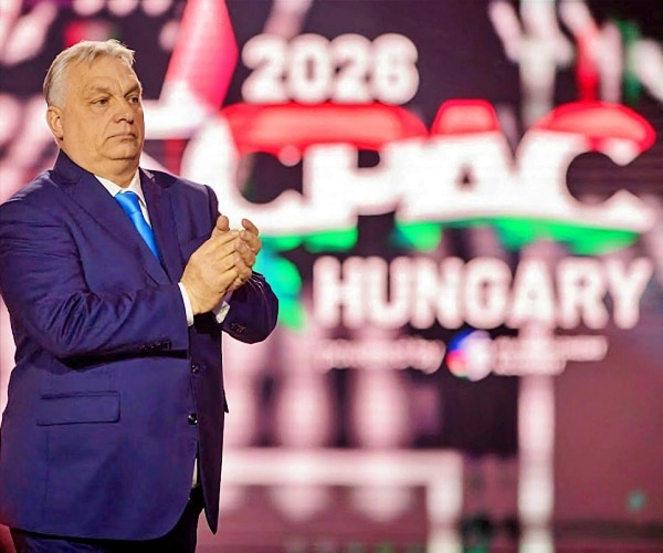 viktor orban in front of a large cpac screen