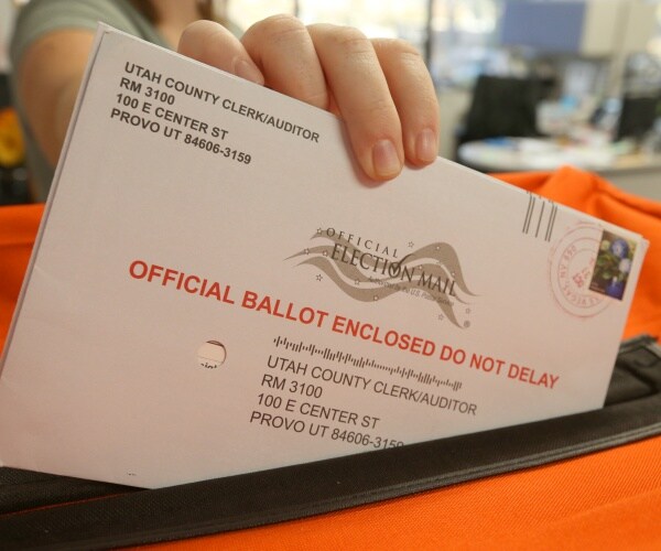 envelope holding a mail in ballot is put into an orange box
