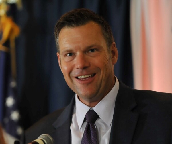 kobach in a suit and navy blue tie 