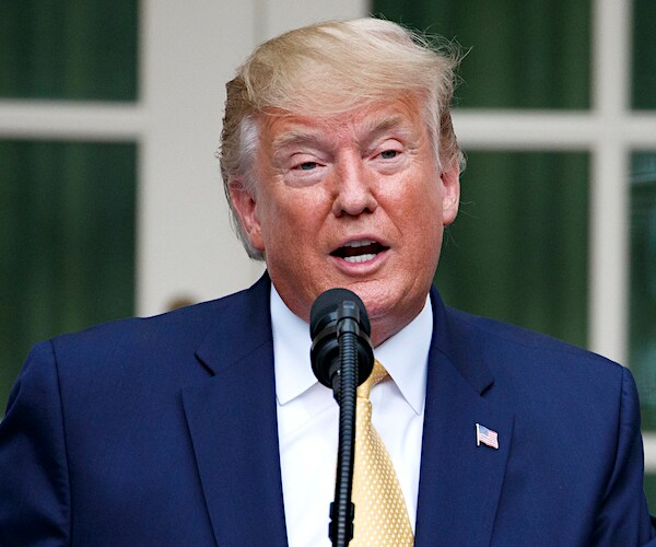 president donald trump speaks into a mic during a white house rose garden speech