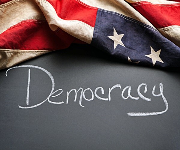 democracy sign written on a chalkboard with vintage american flag 

