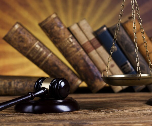 graphic shows a gavel along with law books in the background and part of a  justice scale