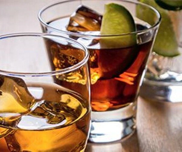 three glasses with ice and different liquors in them