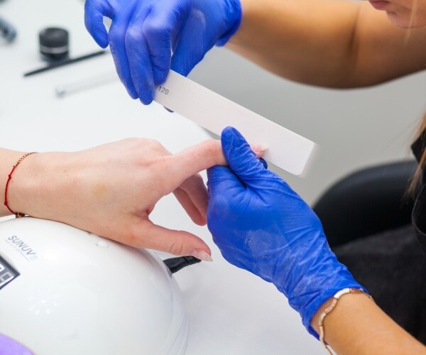 woman getting a manicure in nail salon