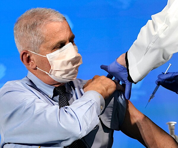 doctor anthony fauci lifts his sleeve and takes the moderna vaccine