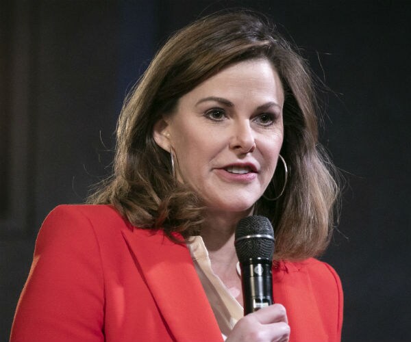 campbell brown is shown in red jacket holding black microphone