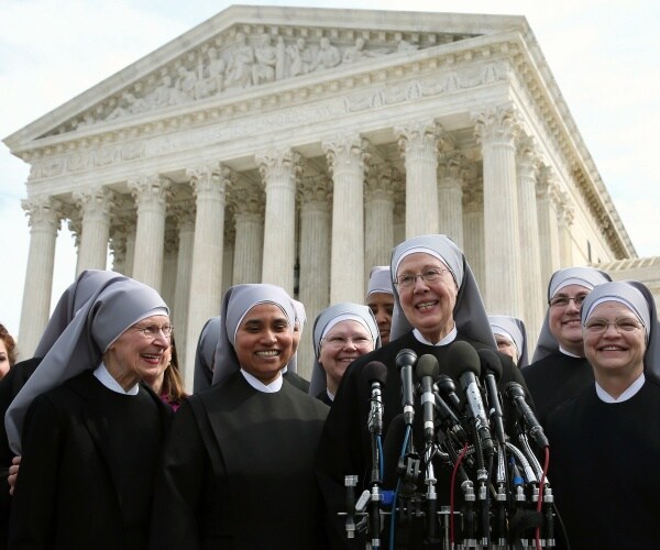 little sisters of the poor stand in front of the us supreme court building wearing black and gray