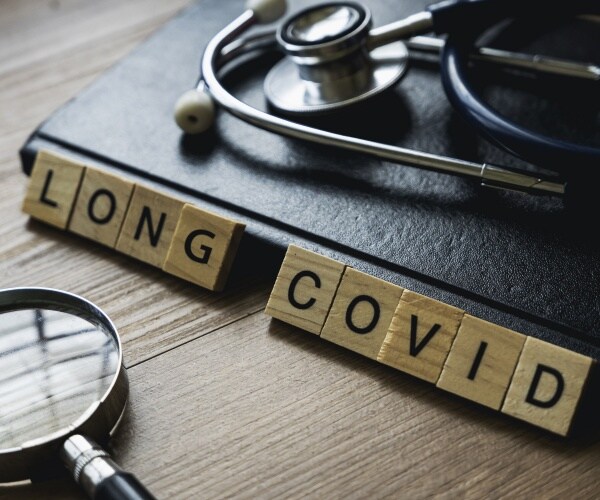 'Long COVID' in blocks, laptop, magnifying glass