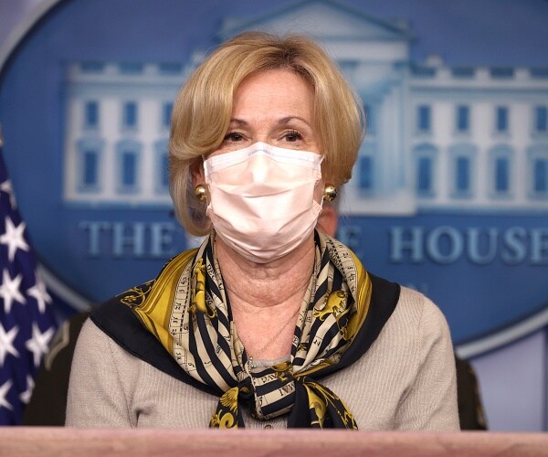 deborah birx stands behind podium in briefing room