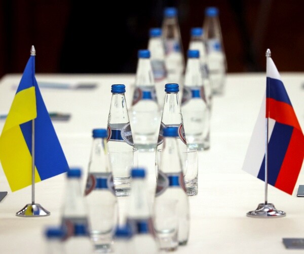 Ukrainian and Russian national flags are placed on the table 
