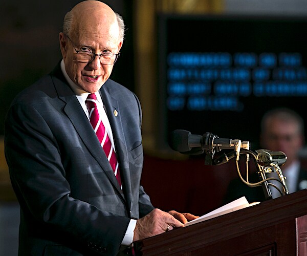 pat roberts stands at a lectern during a news conference