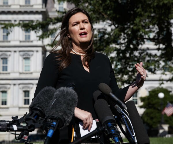 press secretary sarah sanders talks with reporters outside the white house, wearing a black dress and pearls