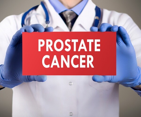 physician holding sign saying 'prostate cancer'