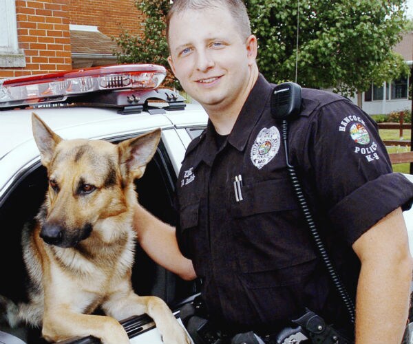 a police officer is shown with a german shephard