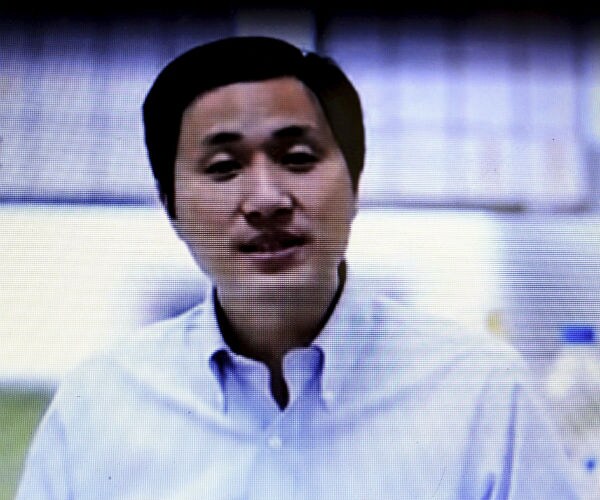 in this screen shot, he jiankui, speaks during an interview
