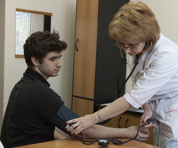 doctor takes patients blood pressure