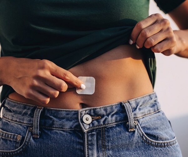 woman applying an estrogen patch to stomach