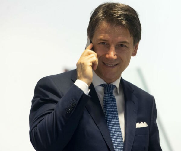 Italy Prime Minister Giuseppe Conte talks on the phone inside a mobile phones shop in the center of Rome