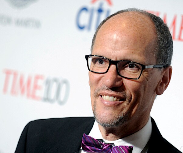 tom perez smiles during an appearance on a red carpet