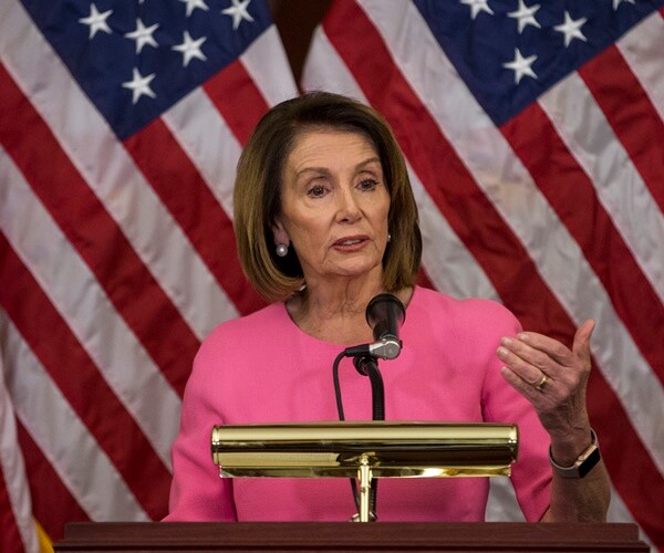 speaker nancy pelosi stands in front of the united states flag