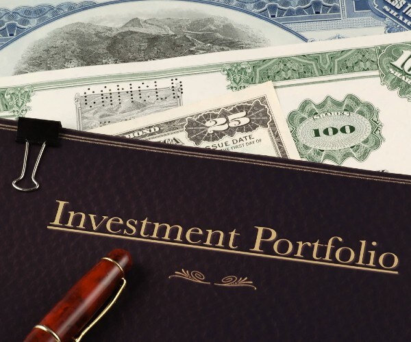 investment portfolio on top of vintage stock and bond certificates
