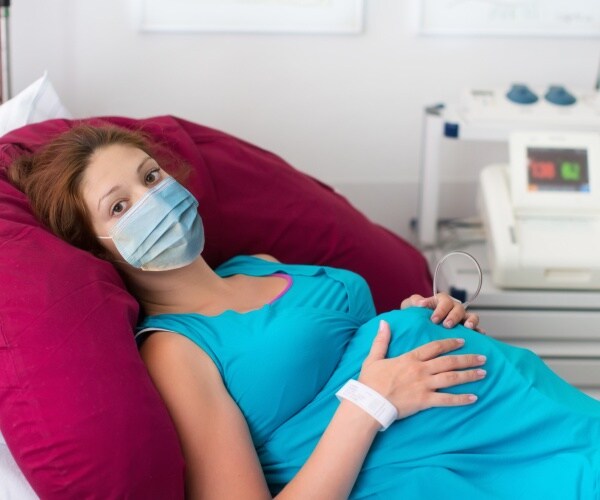 pregnant woman at doctor's appointment wearing mask