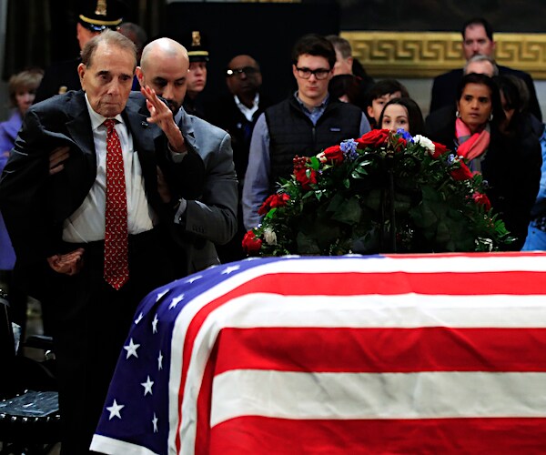 bob dole stands to salute the casket of former president george herbert walker bush
