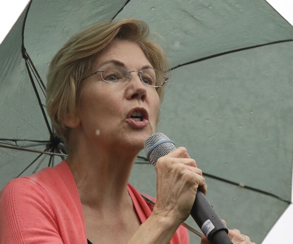 sen. elizabeth warren speaking in new hampshire while holding a green unbrella