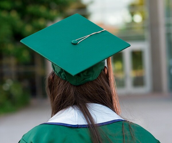 back view of woman wearing green cap and gown