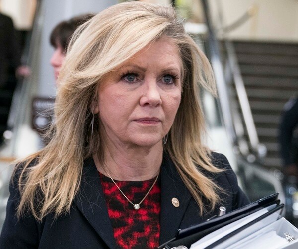 marsha blackburn walks past escalators with guards standing by