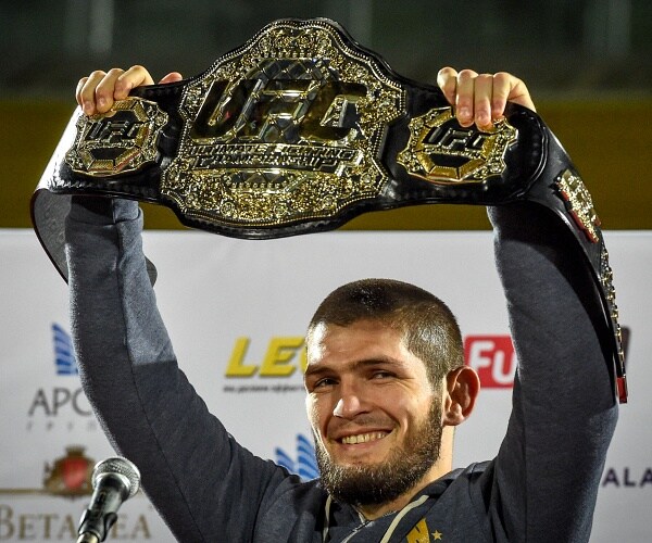 khabib nurmagomedov raises chamionship belt overhead