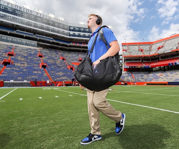 kyle trask walks through an empty stadium