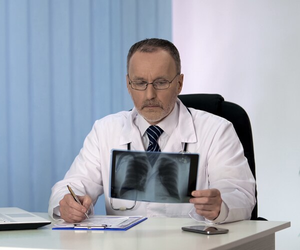a doctor examines a chest x-ray