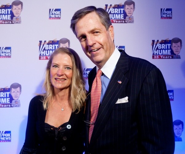 brit hume in a suit and red patterned tie with his wife wearing a black dress