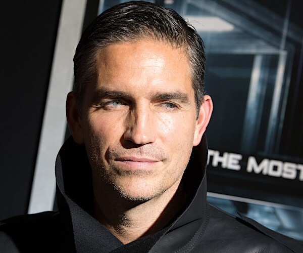 actor jim caviezel stands on the red carpet in a leather jacket with his collar popped